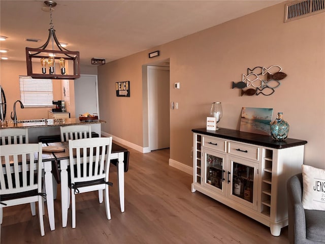 dining space featuring wood-type flooring and sink