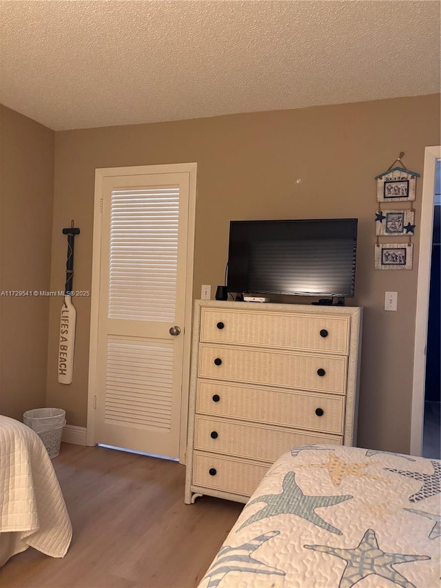 bedroom featuring dark wood-type flooring and a textured ceiling