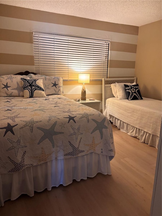 bedroom featuring a textured ceiling and light hardwood / wood-style flooring