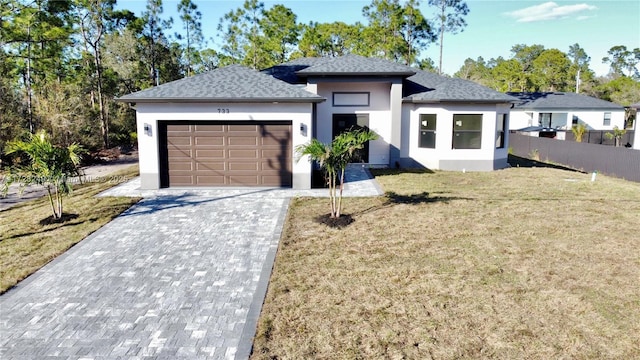 prairie-style house featuring a garage and a front lawn