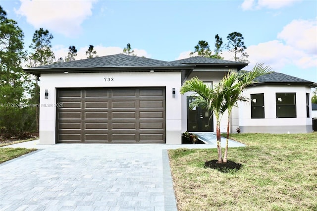 view of front of home with a garage and a front lawn