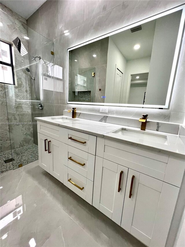 kitchen with light stone countertops, appliances with stainless steel finishes, a kitchen island, decorative light fixtures, and white cabinetry