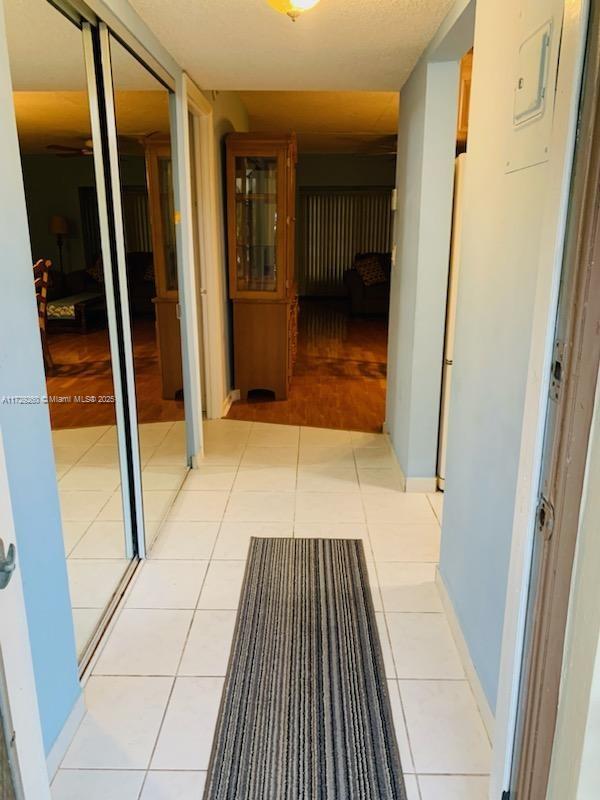 hall featuring light tile patterned floors