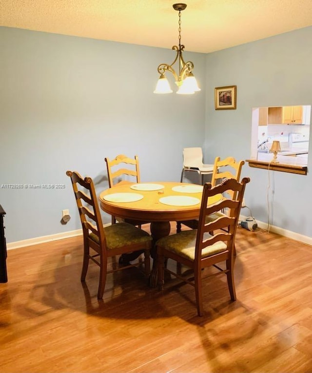 dining space featuring light hardwood / wood-style floors and a chandelier