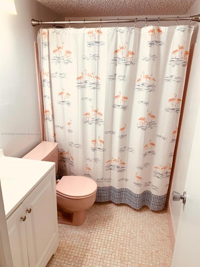 bathroom featuring toilet, vanity, a textured ceiling, and curtained shower