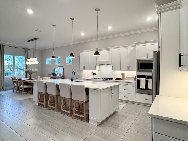 kitchen featuring sink, white cabinetry, stainless steel appliances, and a kitchen island with sink