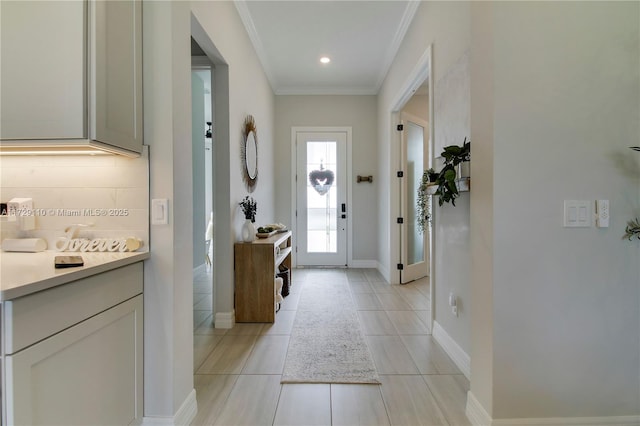 doorway with light tile patterned floors and crown molding