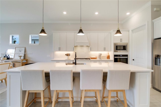 kitchen featuring white cabinets, hanging light fixtures, appliances with stainless steel finishes, and a large island