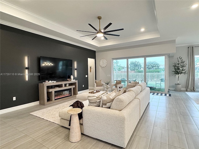 living room with ceiling fan, light tile patterned floors, a tray ceiling, and crown molding