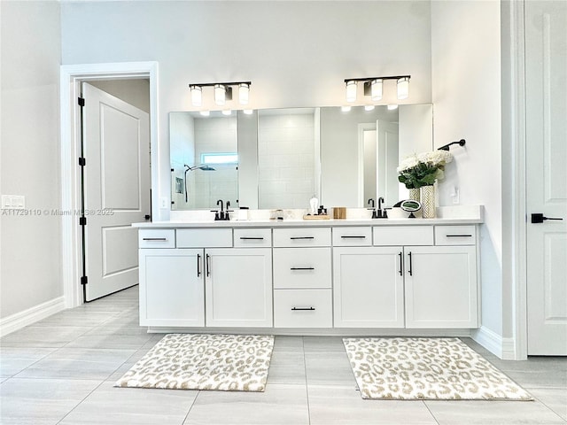 bathroom featuring a tile shower, tile patterned flooring, and vanity