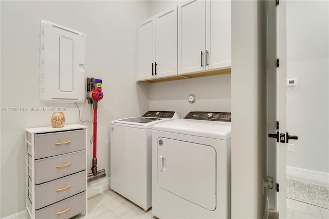 laundry room featuring electric panel, washing machine and dryer, light tile patterned floors, and cabinets