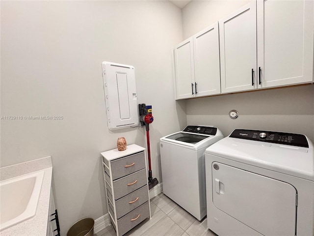 laundry area featuring cabinets, washer and clothes dryer, sink, and light tile patterned flooring