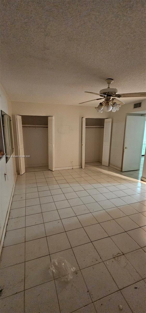 empty room featuring a textured ceiling and ceiling fan