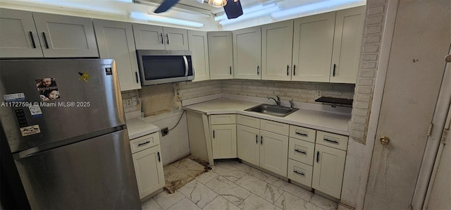 kitchen with ceiling fan, sink, stainless steel appliances, and tasteful backsplash