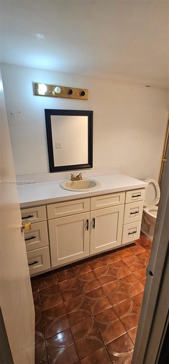 bathroom featuring toilet, vanity, and tile patterned flooring