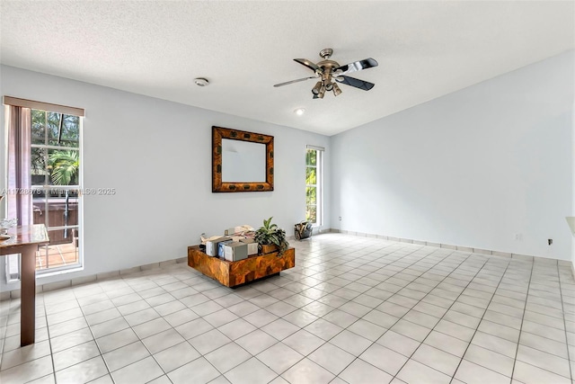 interior space featuring ceiling fan, a wealth of natural light, light tile patterned floors, and a textured ceiling