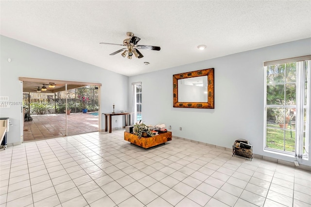 living area featuring light tile patterned floors, vaulted ceiling, and ceiling fan