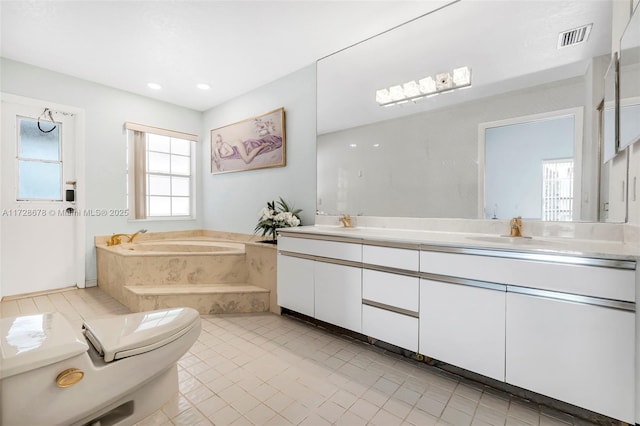 bathroom with a bath, toilet, and vanity