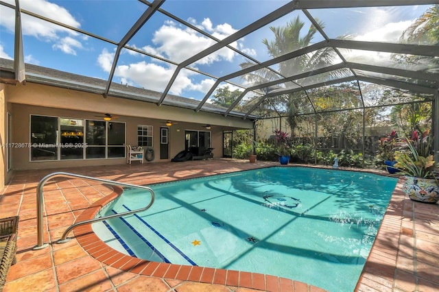 view of swimming pool with ceiling fan, a patio, and a lanai