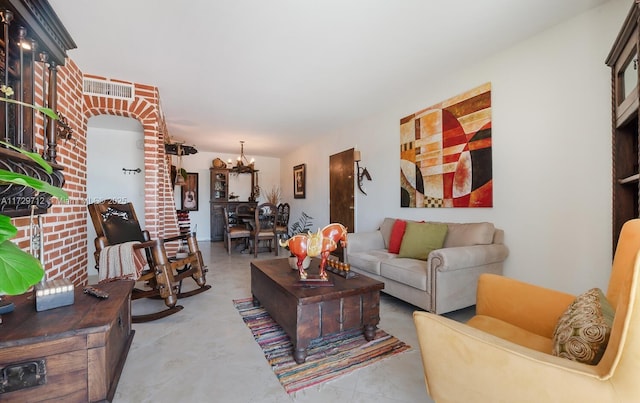 living room with concrete floors and an inviting chandelier