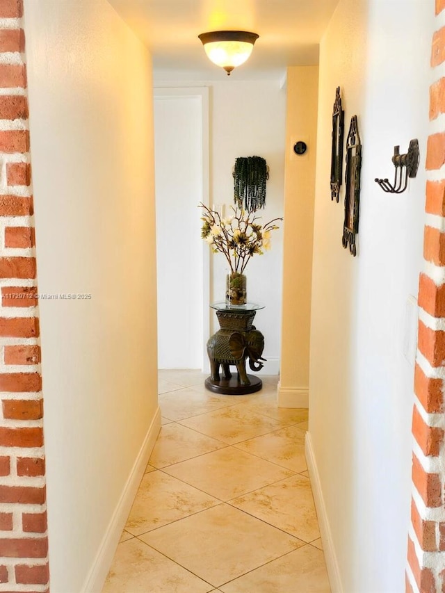 hallway with light tile patterned floors and baseboards