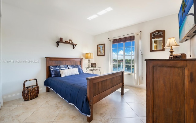 bedroom with light tile patterned floors and baseboards