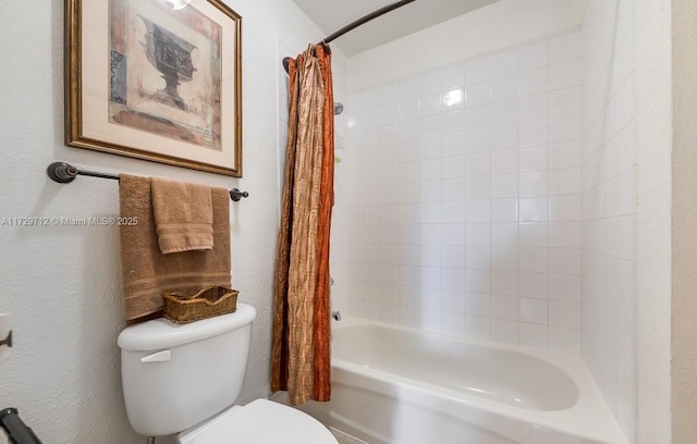 bathroom featuring toilet, shower / bath combo with shower curtain, and a textured wall