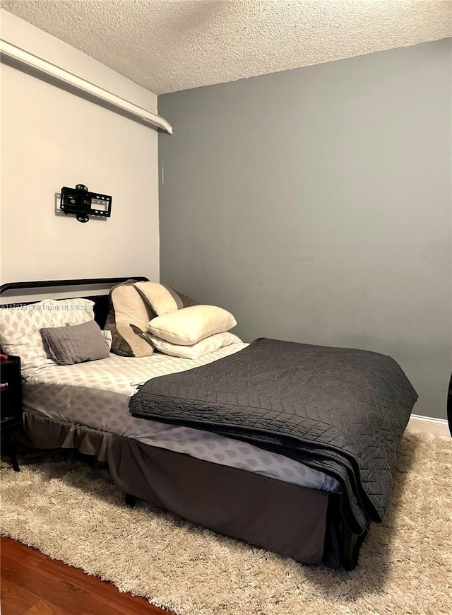 bedroom featuring hardwood / wood-style flooring and a textured ceiling