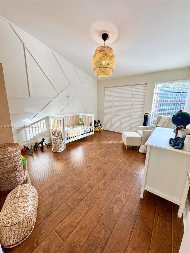 bedroom with hardwood / wood-style flooring and a nursery area