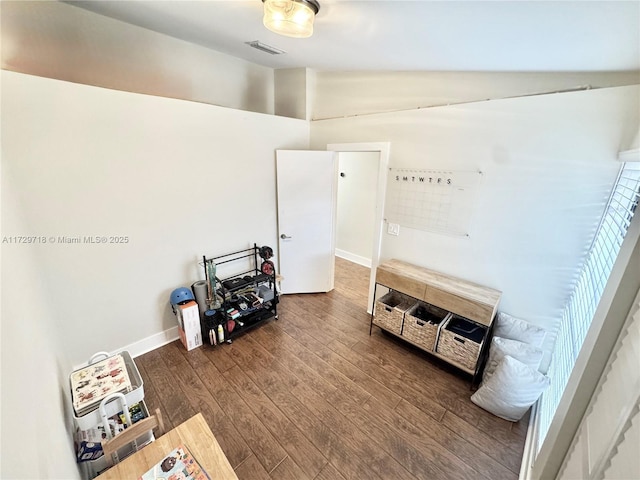 misc room with dark wood-type flooring and vaulted ceiling