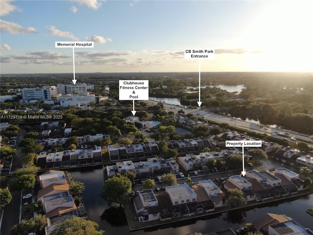 aerial view at dusk featuring a water view