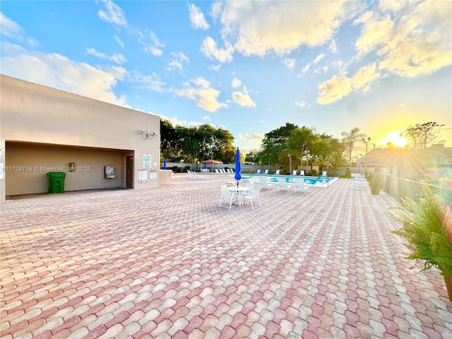 patio terrace at dusk with a community pool