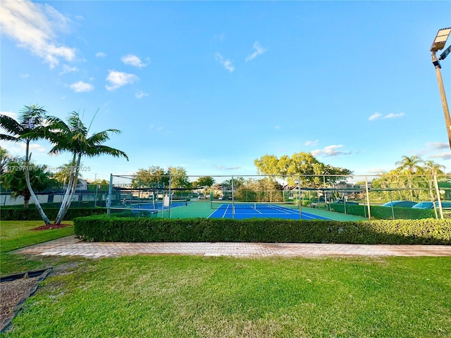 view of home's community with a yard and tennis court