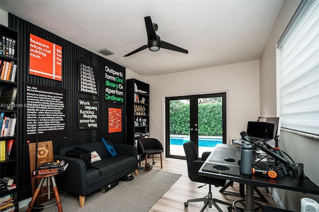 office area with light wood-type flooring, ceiling fan, french doors, and a textured ceiling