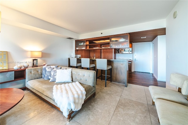 tiled living room featuring bar area