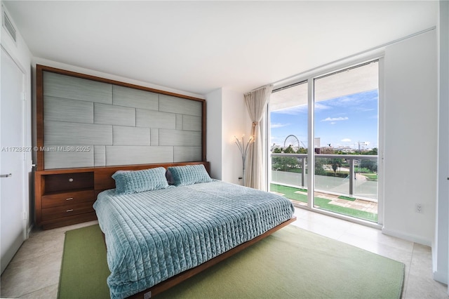 tiled bedroom with expansive windows and access to outside