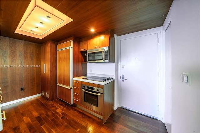 kitchen featuring wood walls, dark wood-type flooring, stainless steel appliances, and wood ceiling