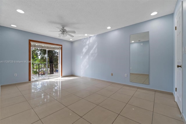 tiled empty room featuring ceiling fan and a textured ceiling