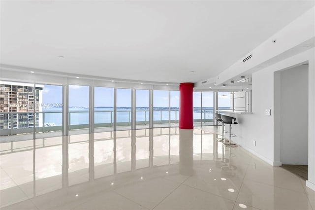 tiled spare room with a water view and floor to ceiling windows