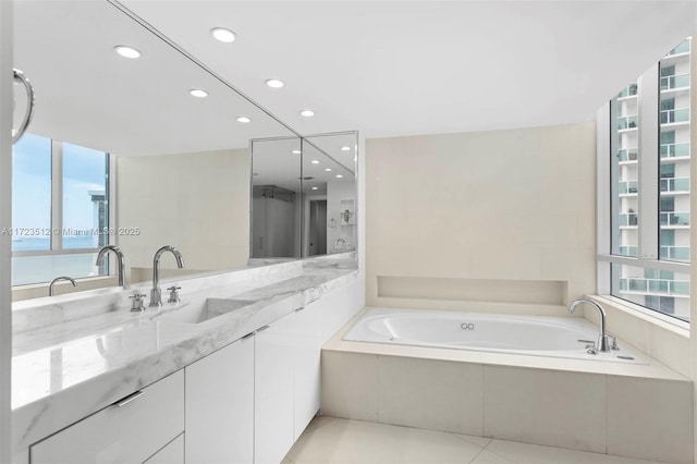 bathroom with a water view, tiled tub, tile patterned floors, and vanity