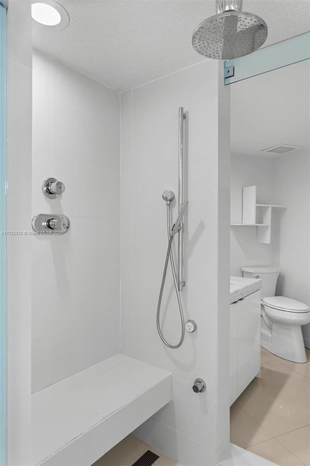 bathroom featuring toilet, walk in shower, and tile patterned flooring