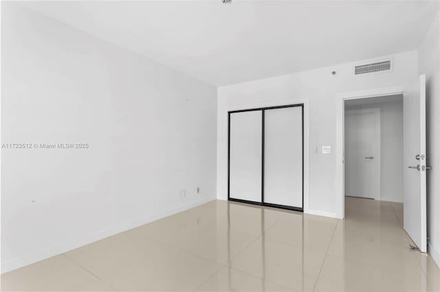 unfurnished bedroom featuring a closet and light tile patterned flooring