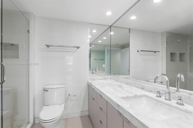 bathroom featuring tile walls, toilet, vanity, and walk in shower