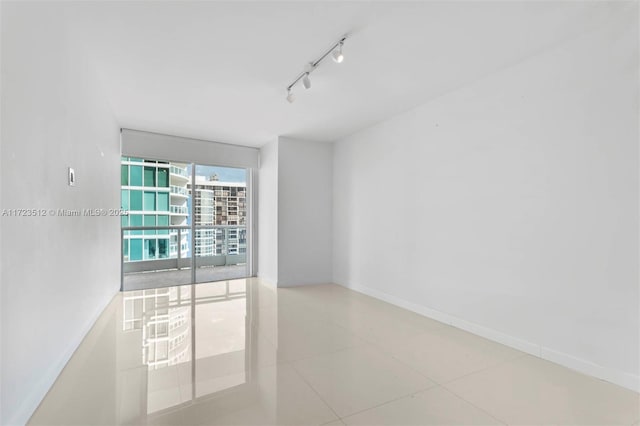 spare room featuring tile patterned flooring and track lighting