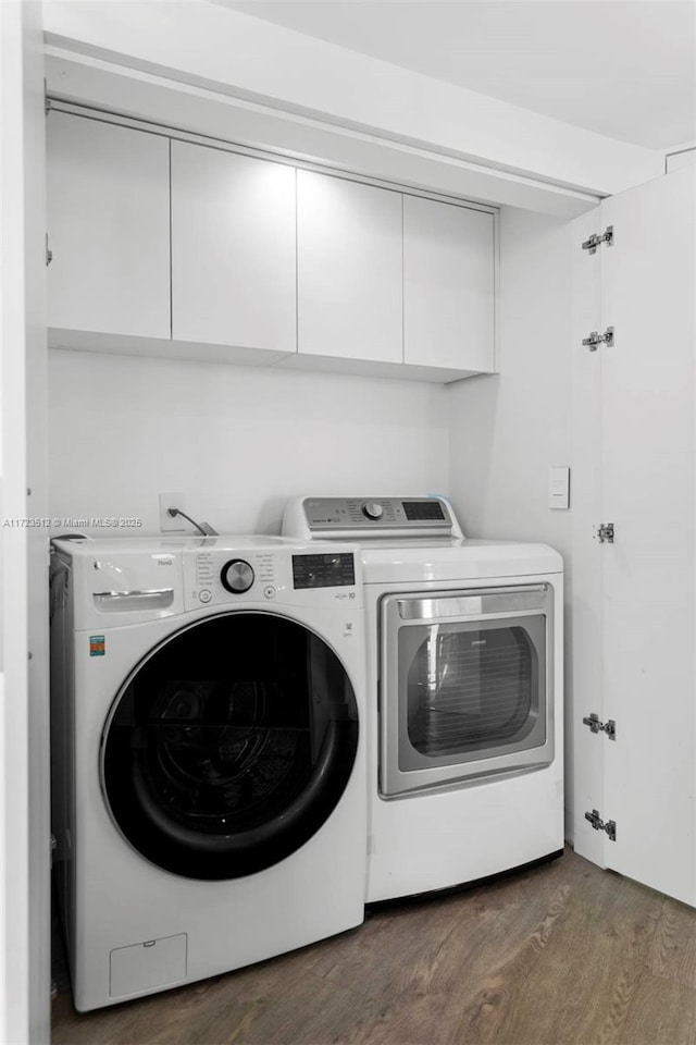 washroom featuring cabinets, washer and dryer, and dark hardwood / wood-style flooring