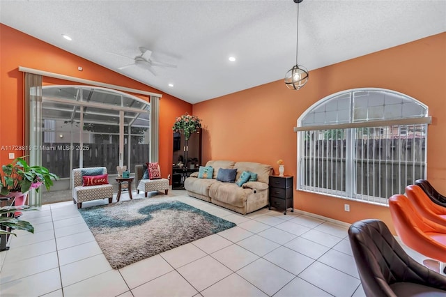 living room with a textured ceiling, ceiling fan, light tile patterned floors, and lofted ceiling