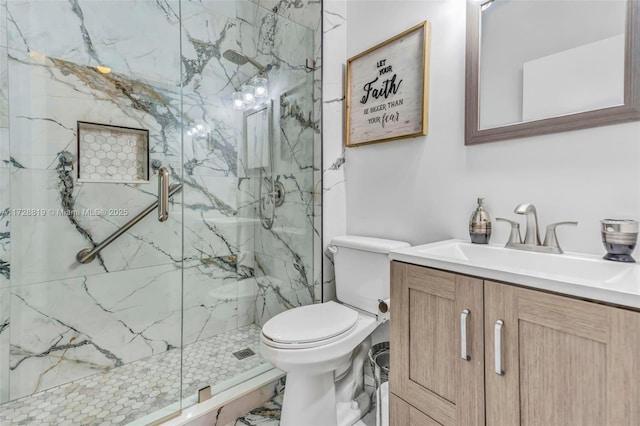 bathroom with toilet, vanity, and a shower with door