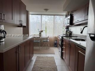 kitchen featuring sink, light tile patterned floors, and appliances with stainless steel finishes