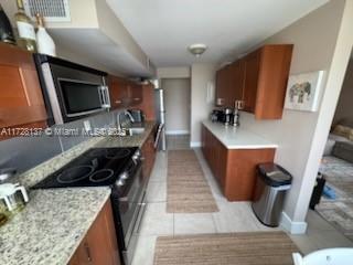 kitchen with sink, black electric range oven, and light tile patterned flooring