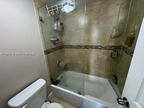 bathroom featuring enclosed tub / shower combo and toilet